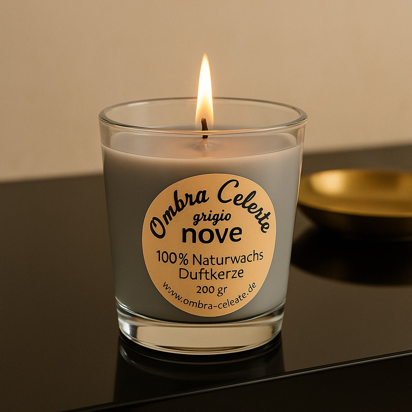 Ombra Celeste nove grigio auf schwarzem Hochglanztisch mit goldener Schale – brennend, edel inszeniert