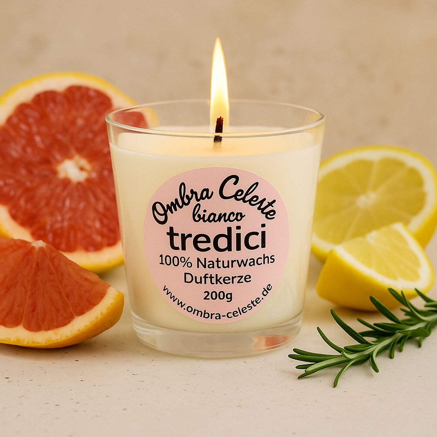 Ombra Celeste tredici bianco Duftkerze mit brennender Flamme, dekoriert mit Grapefruit, Zitrone und Rosmarin.