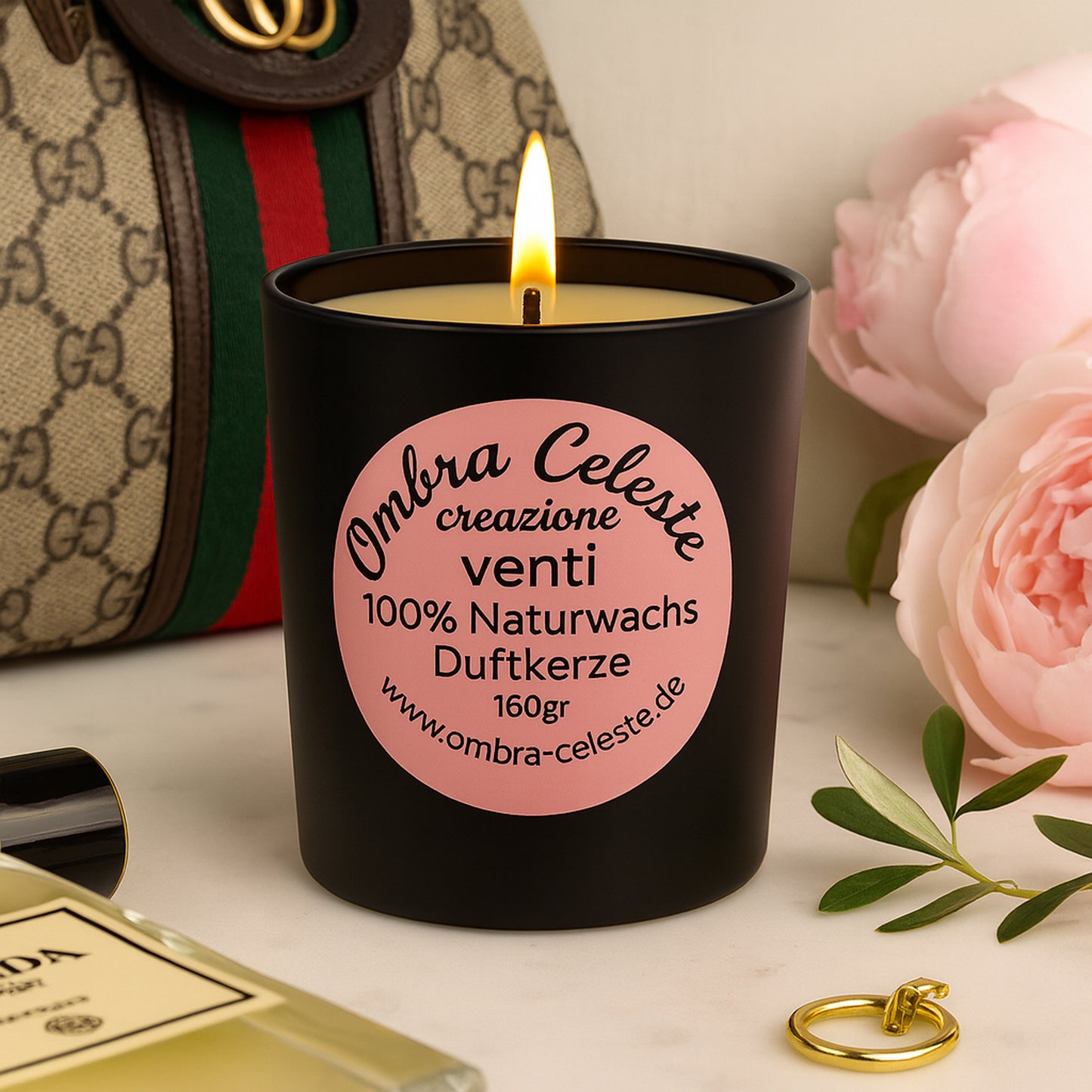 Edles Galleriebild der Duftkerze Ombra Celeste venti im schwarzen Glas mit rosa Etikett, stilvoll inszeniert mit Gucci-Tasche, Prada-Parfum und rosa Pfingstrosen im luxuriösen Stil