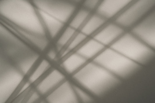 Abstrakte Licht- und Schattenlinien, die sich kreuzen und wie flüchtige Bewegungen wirken – ein visuelles Echo menschlicher Gesten.