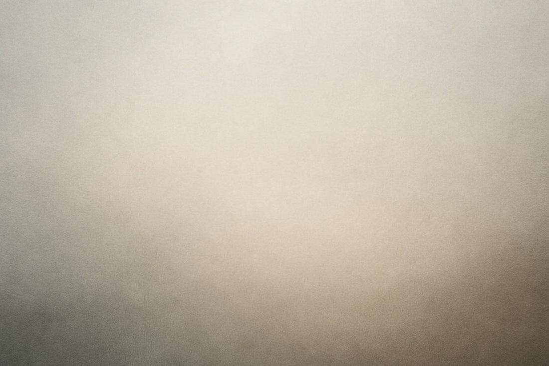 Ein sanfter Schleier aus hellem Grau und warmem Beige, der nach unten in dunklere Tiefe sinkt – wie ein Atemzug, der sich im Raum verliert.