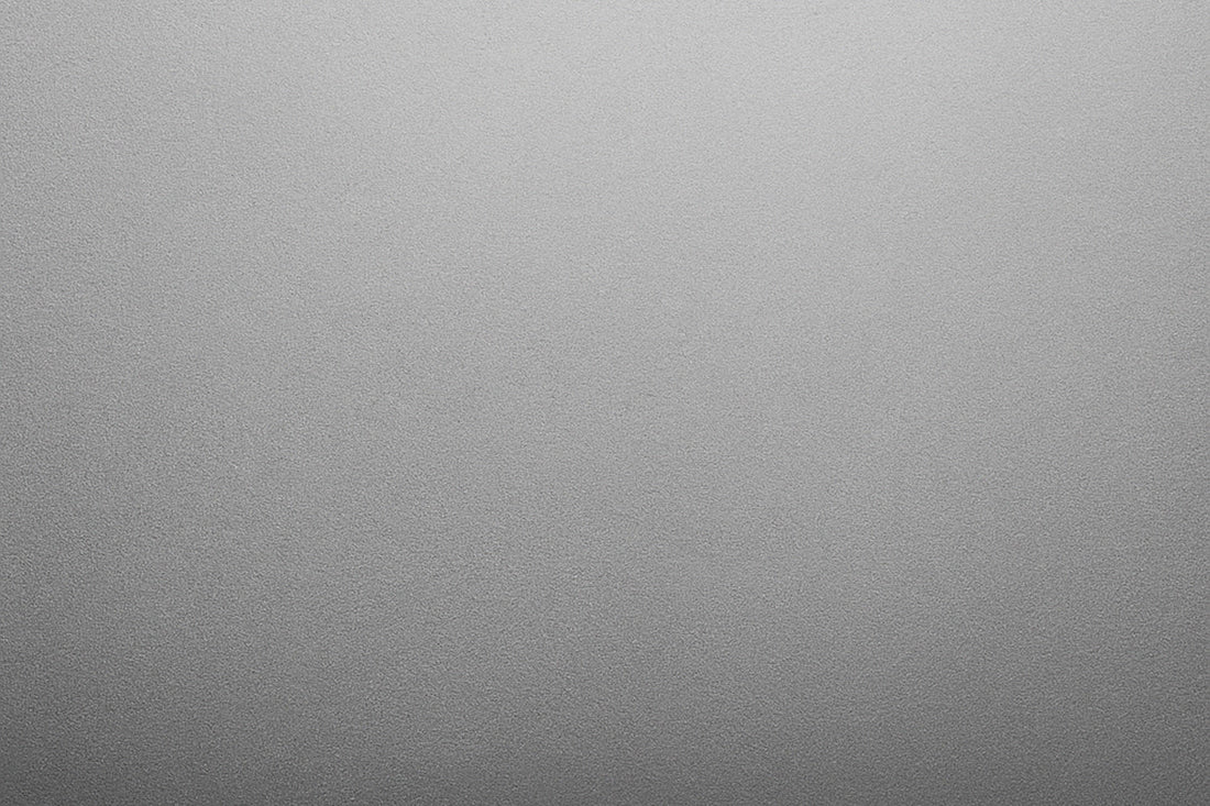 Eine monochrome, sanft gekörnte Fläche mit weichem Helligkeitsverlauf erzeugt eine ruhige, minimalistische Stimmung ohne erkennbares Motiv.