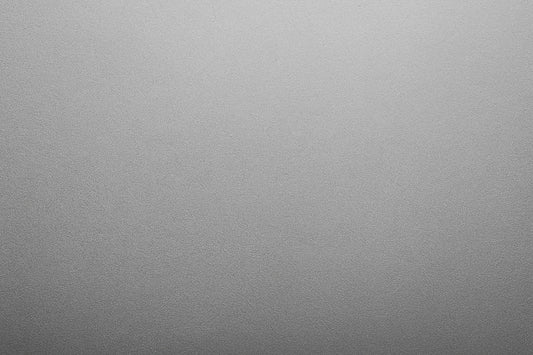 Eine monochrome, sanft gekörnte Fläche mit weichem Helligkeitsverlauf erzeugt eine ruhige, minimalistische Stimmung ohne erkennbares Motiv.