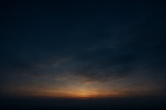 Ein weiter, dunkler Himmel mit einem zarten goldenen Nachglühen über dem Horizont. Das Licht vergeht, doch seine Wärme bleibt spürbar – Symbol für Erinnerung, Wandel und Stille.