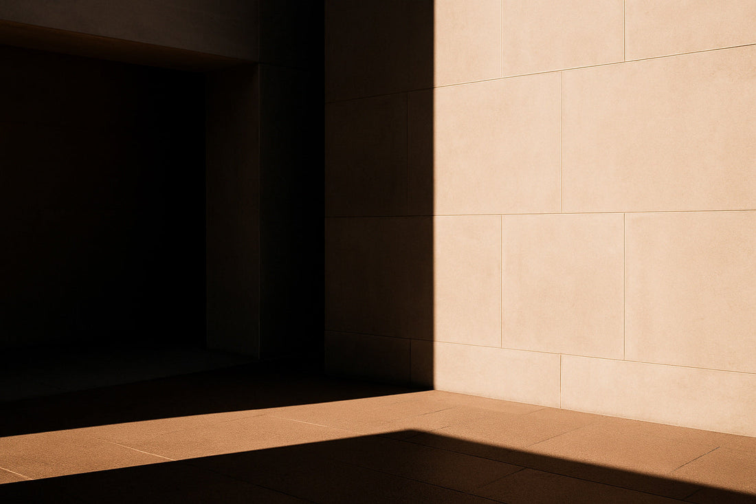 Minimalistische Außenarchitektur mit klaren Linien und starkem Schattenverlauf – eine ruhige, kontrastreiche Szene aus hellem Stein und Licht, die Stille und Raumgefühl vermittelt