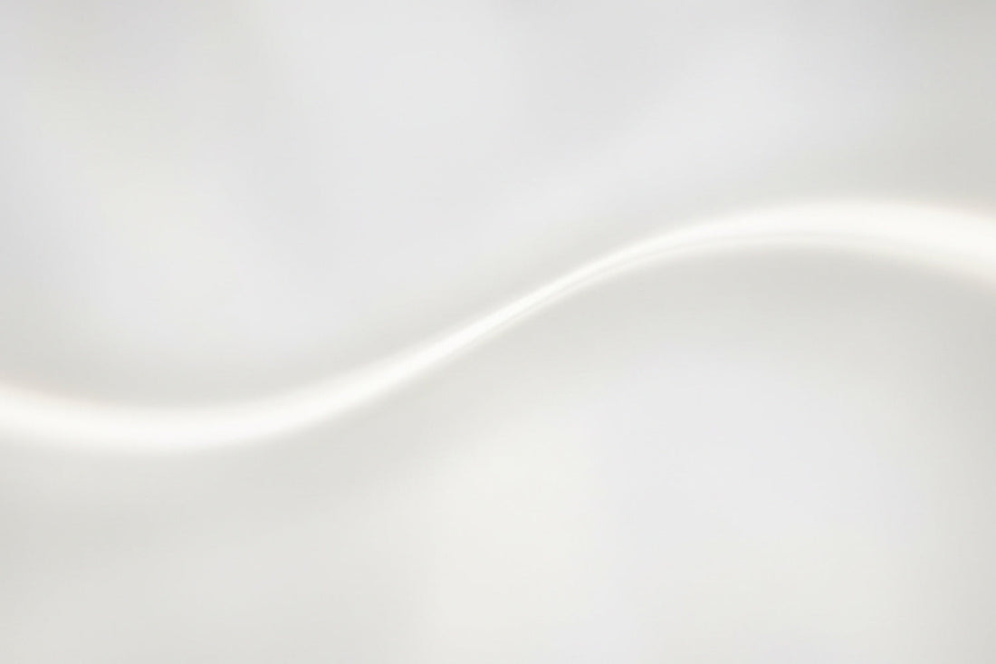 Sanftes Licht fließt in einer weichen, hellen Welle über eine glatte Fläche – abstrakt, ruhig und nahezu immateriell. Eine Komposition aus Helligkeit, Leichtigkeit und Bewegung, die die Stille des Lichts spürbar macht.