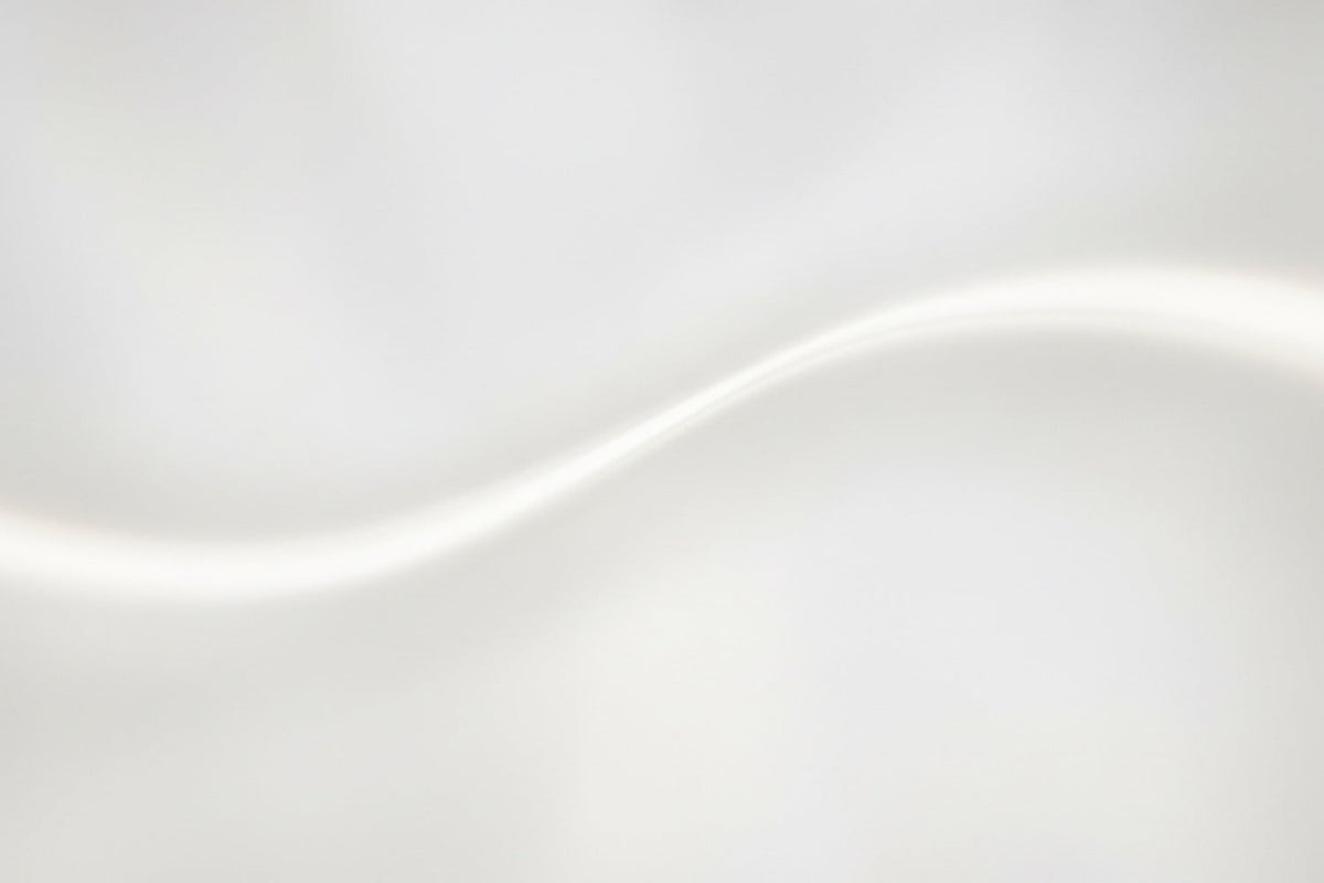 Sanftes Licht fließt in einer weichen, hellen Welle über eine glatte Fläche – abstrakt, ruhig und nahezu immateriell. Eine Komposition aus Helligkeit, Leichtigkeit und Bewegung, die die Stille des Lichts spürbar macht.
