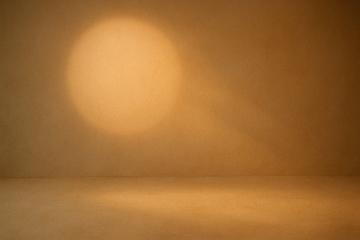 Warm abstrahierter Lichtkreis auf einer sanft strukturierten beige-cremefarbenen Fläche, weiches seitliches Licht und minimalistische Tiefe; ruhige, zurückhaltende Editorial-Ästhetik