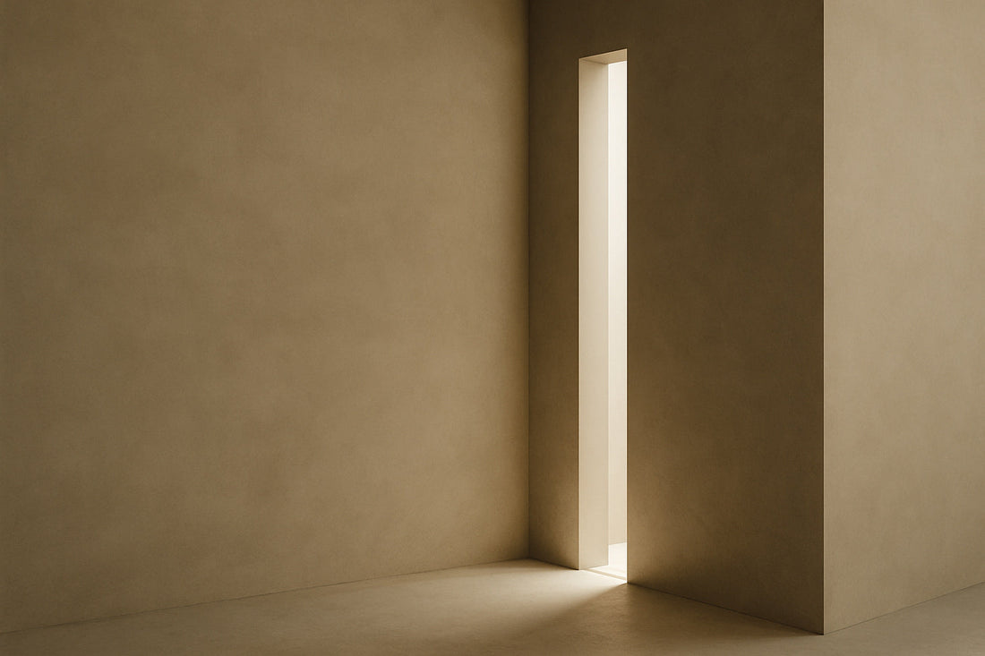 Minimalistische warmgraue Wandarchitektur mit einer schmalen vertikalen Lichtöffnung, durch die weiches Licht auf den Boden fällt; ruhige, moderne, abstrakte Atmosphäre.