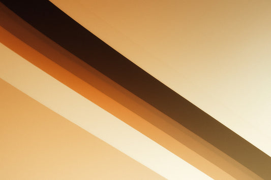 Abstraktes Bild mit klaren, diagonalen Linien in warmen Beige-, Gold- und Sandtönen; harte geometrische Kanten treffen auf weiche Farbverläufe, wodurch eine moderne, ruhige und zugleich strukturierte Editorial-Atmosphäre entsteht.