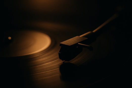 Nahaufnahme einer warm angestrahlten Schallplatte, die Nadel des Plattenspielers schwebt kurz vor dem Aufsetzen – ruhige, intime Hörabend-Atmosphäre