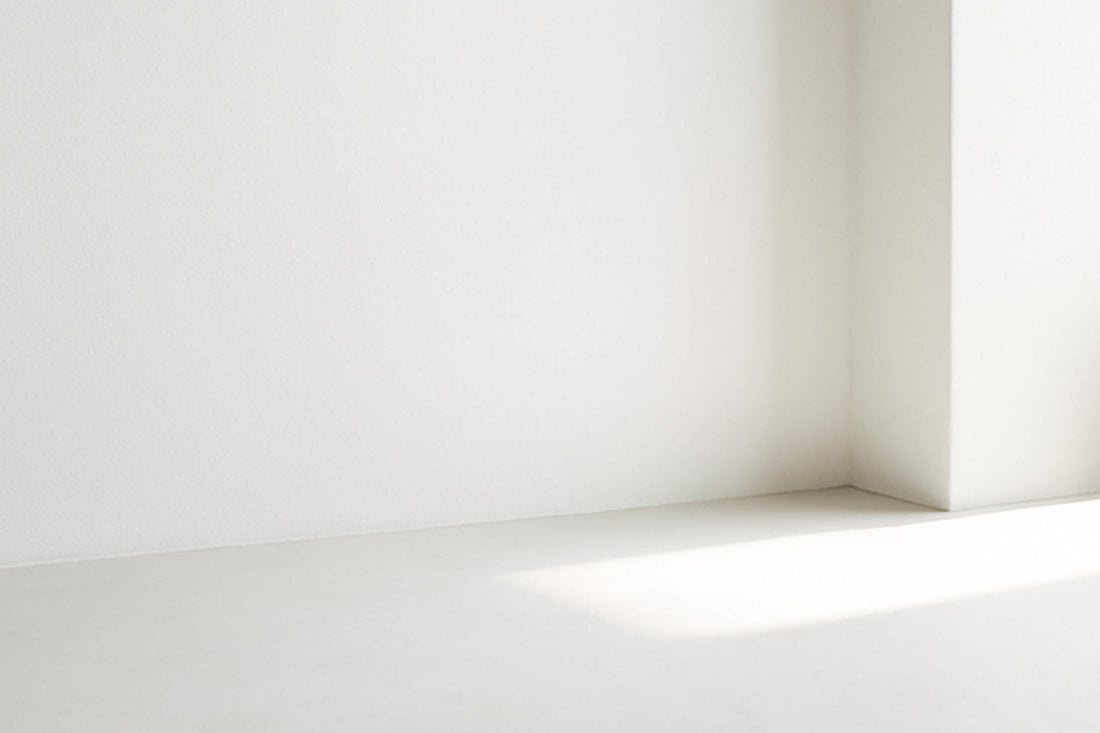 Weiches, silbriges Tageslicht fällt über eine helle Fläche und zeichnet einen feinen Lichtstreifen in minimalistischer, stiller Komposition