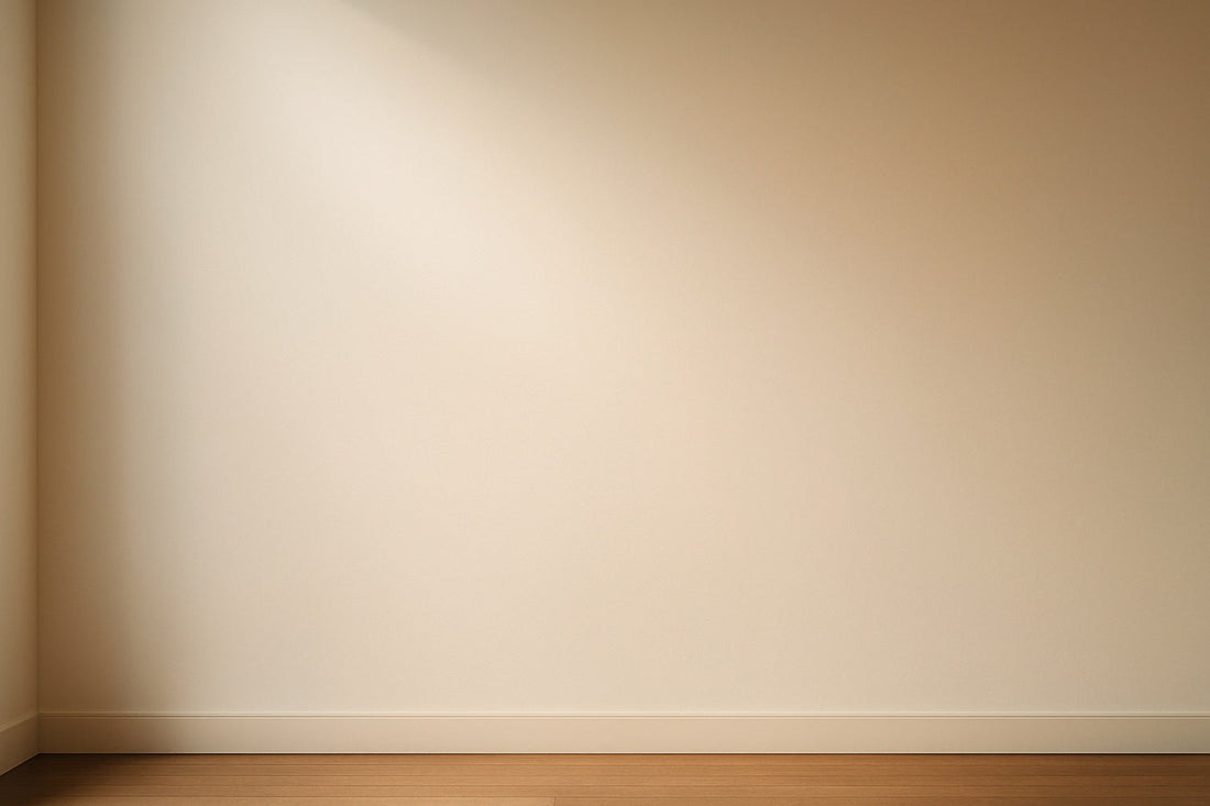 Weiches, warmes Licht fällt auf eine glatte Museumswand und erzeugt eine stille, minimalistische Fläche ohne sichtbare Objekte.